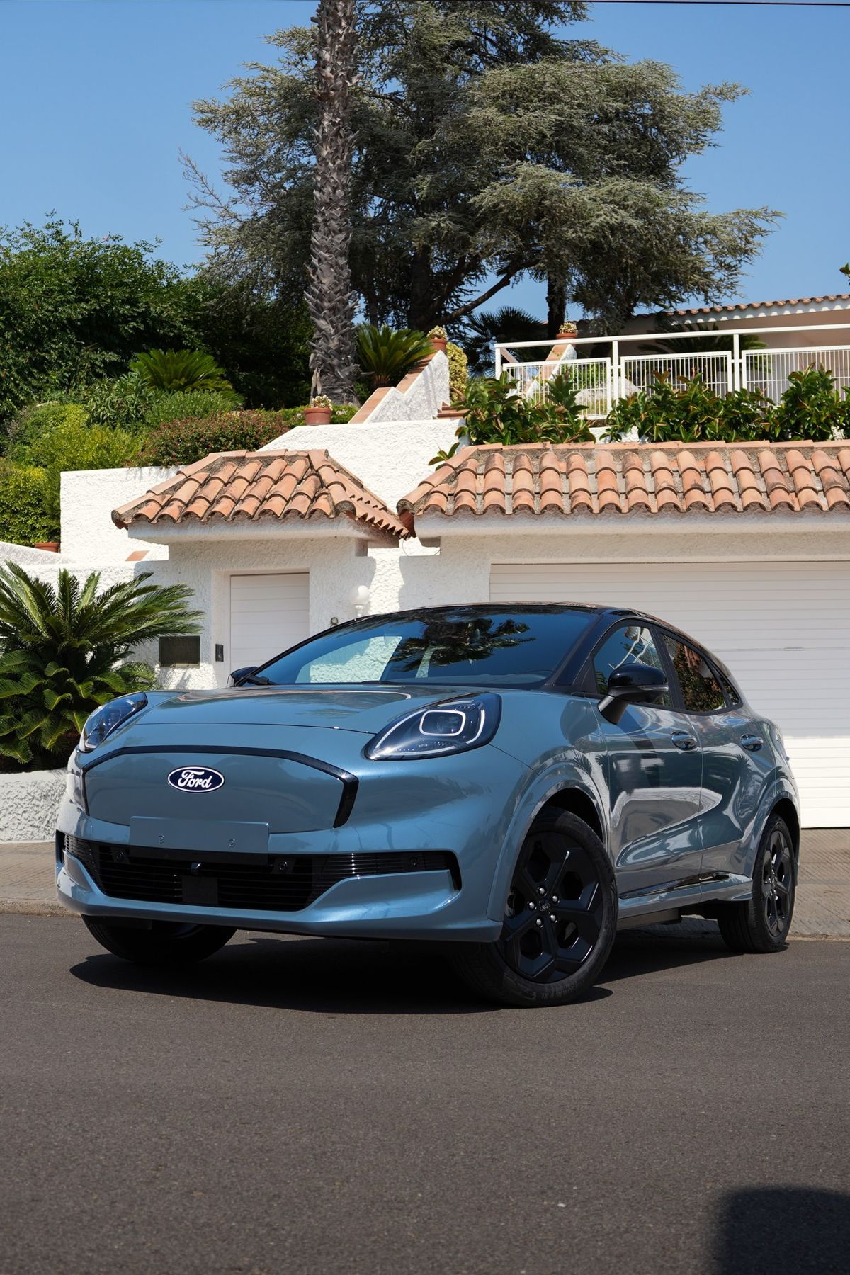Ford Puma azul frente a una casa con tejado de teja